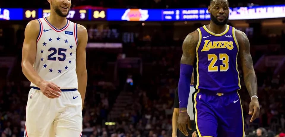 Two basketball players walking on court during game