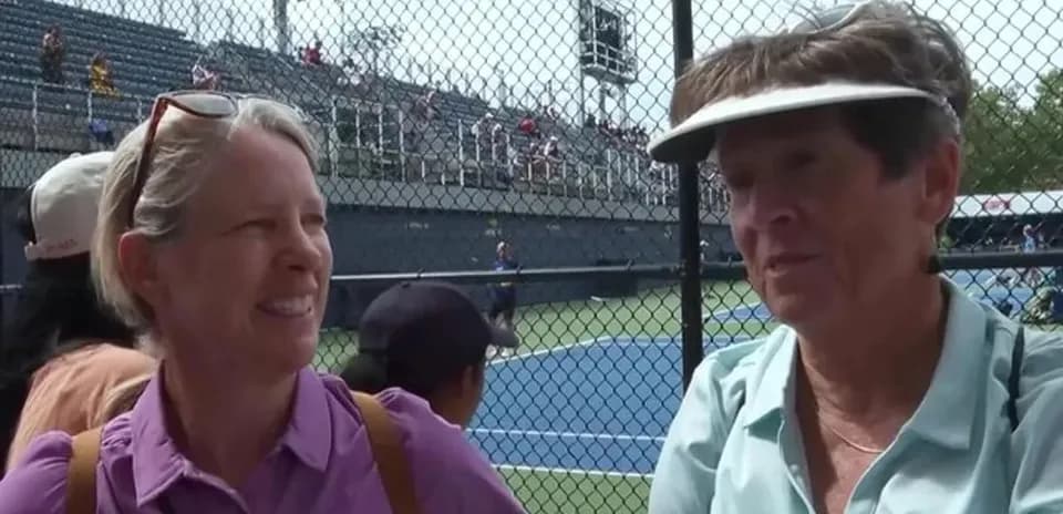 Two women chatting at a tennis event