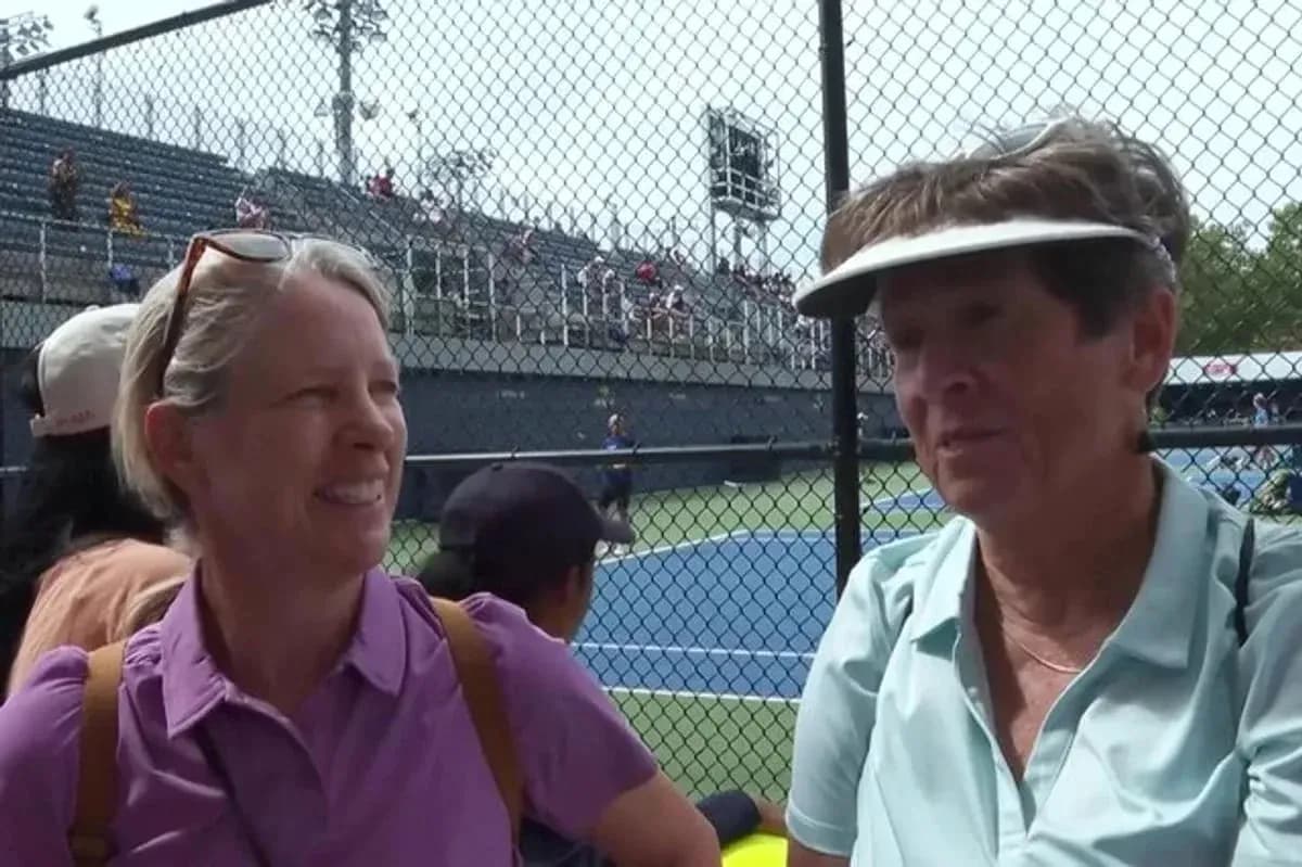 Two women chatting at a tennis event