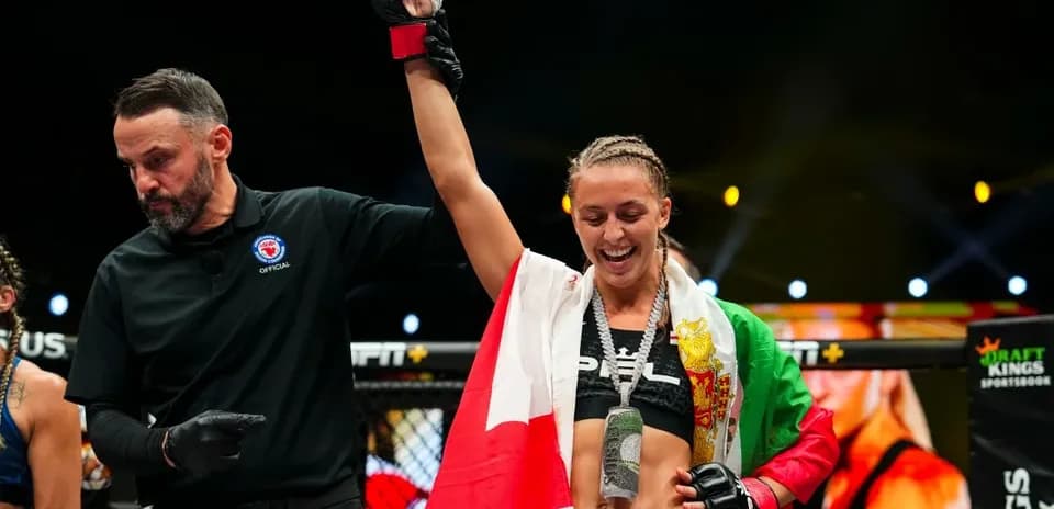 Fighter celebrating victory with referee in ring