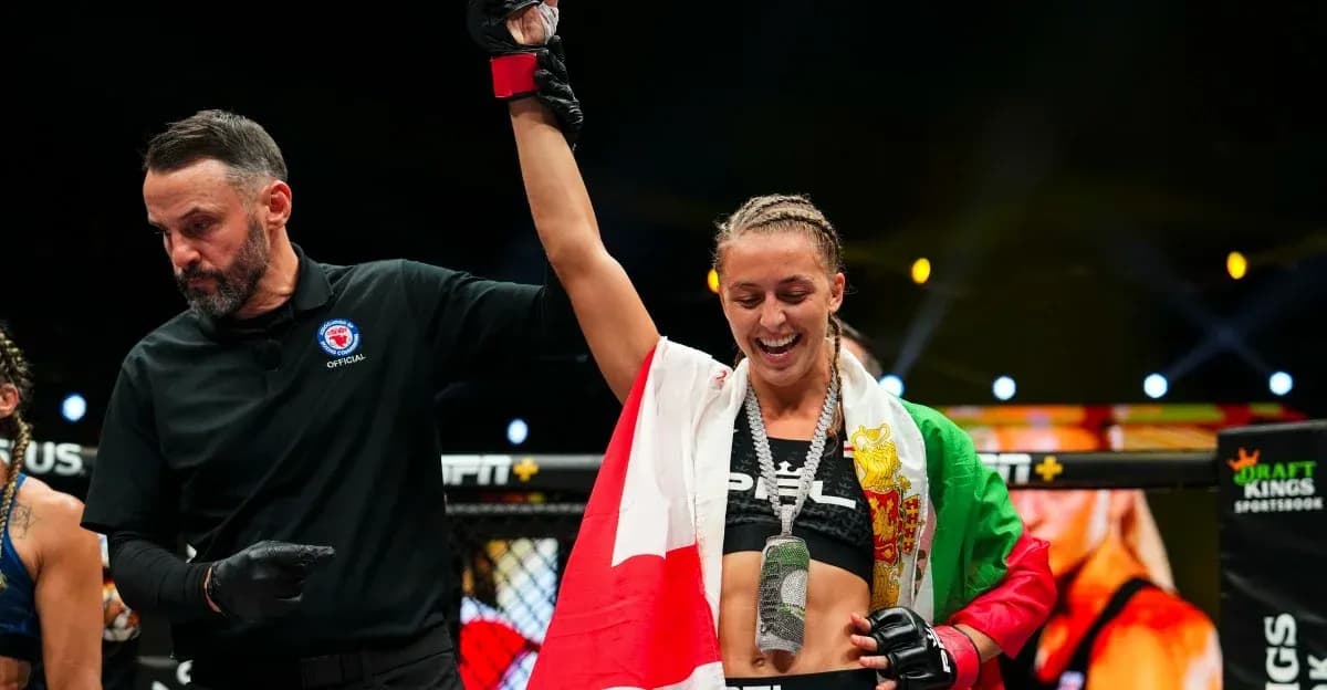 Fighter celebrating victory with referee in ring