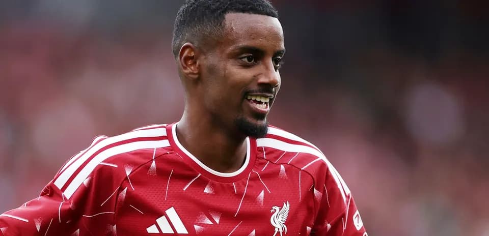 Futbolchi LFC formasida maydonda kulayotgan
