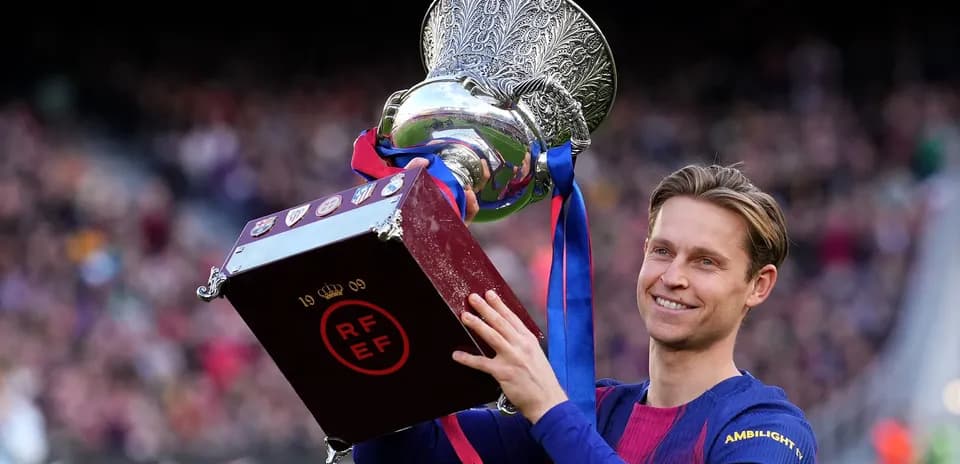 Frenkie de Jong holding trophy at stadium