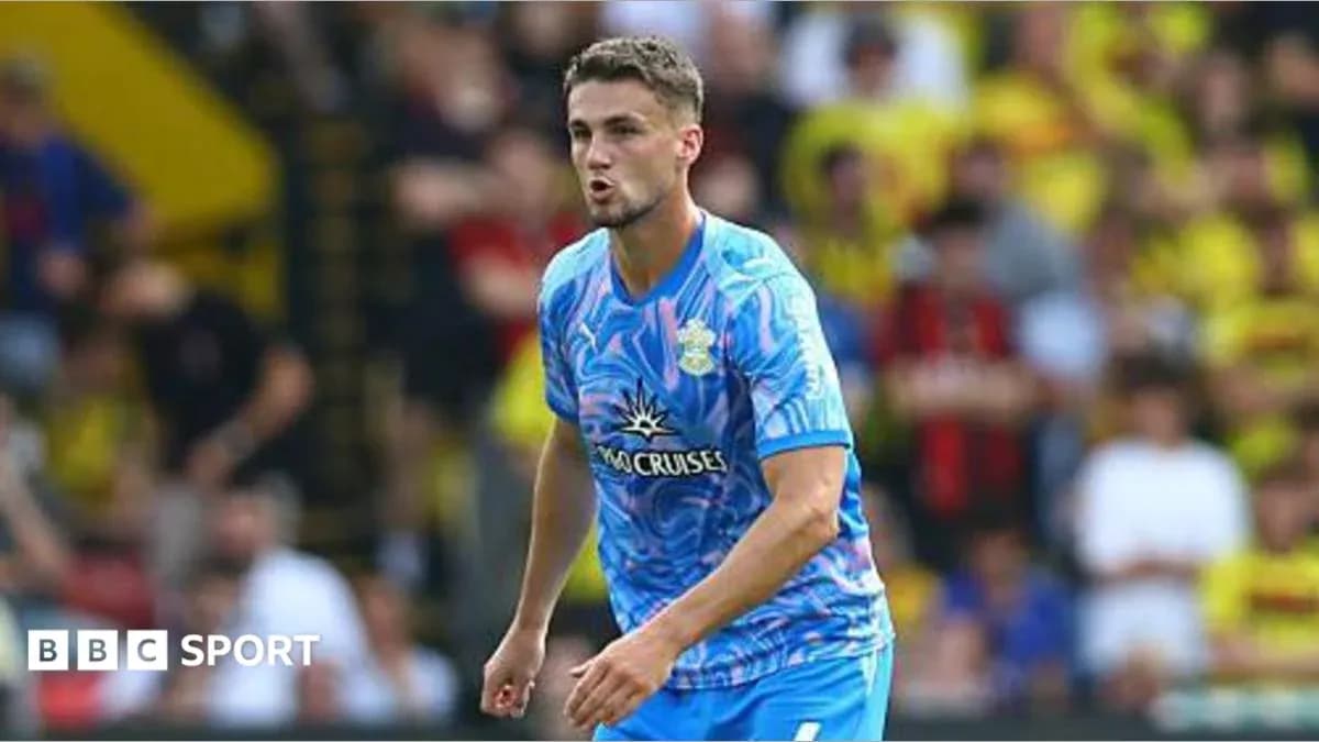 Futbolchi maydonda harakatda, tomoshabinlar ortida