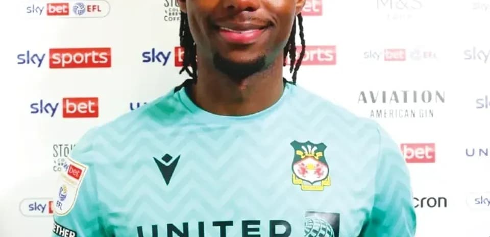 Football player in goalkeeper kit posing for photo