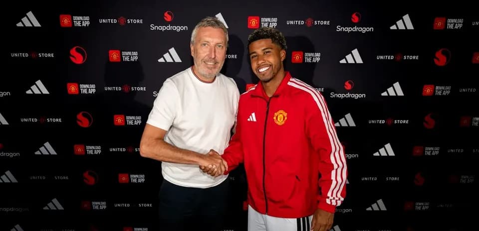 Two men shaking hands at Manchester United signing event