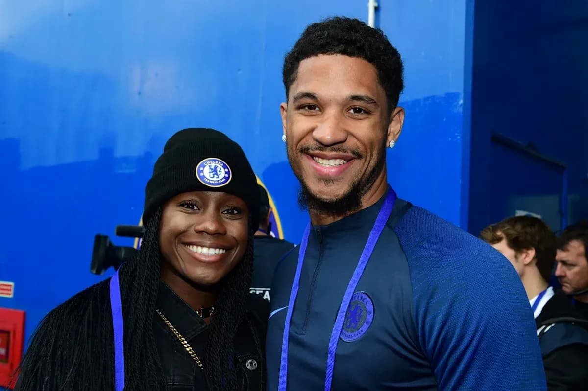 Two Chelsea FC fans posing together, smiling