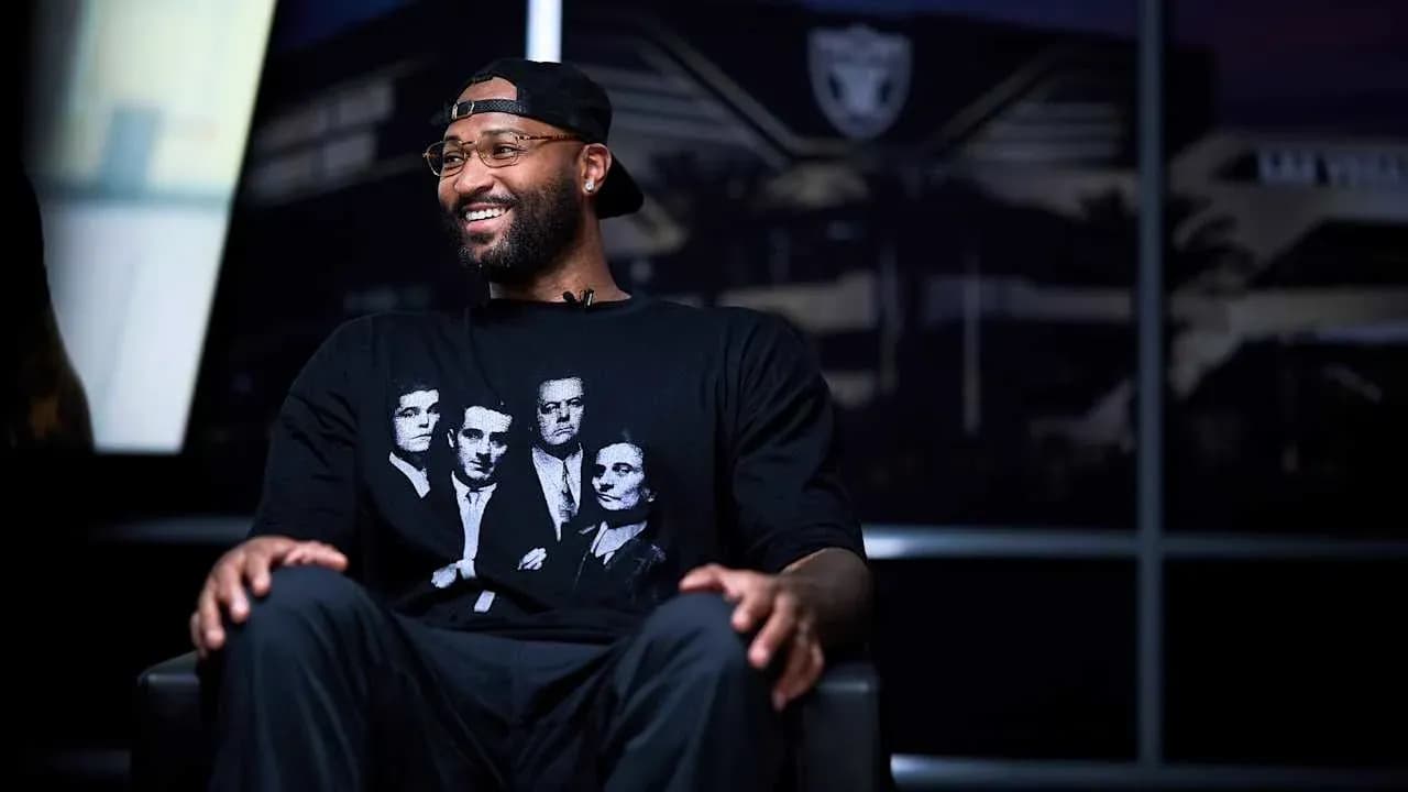 Player sitting in front of team logo backdrop