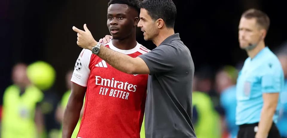 Mikel Arteta speaking with Bukayo Saka during match