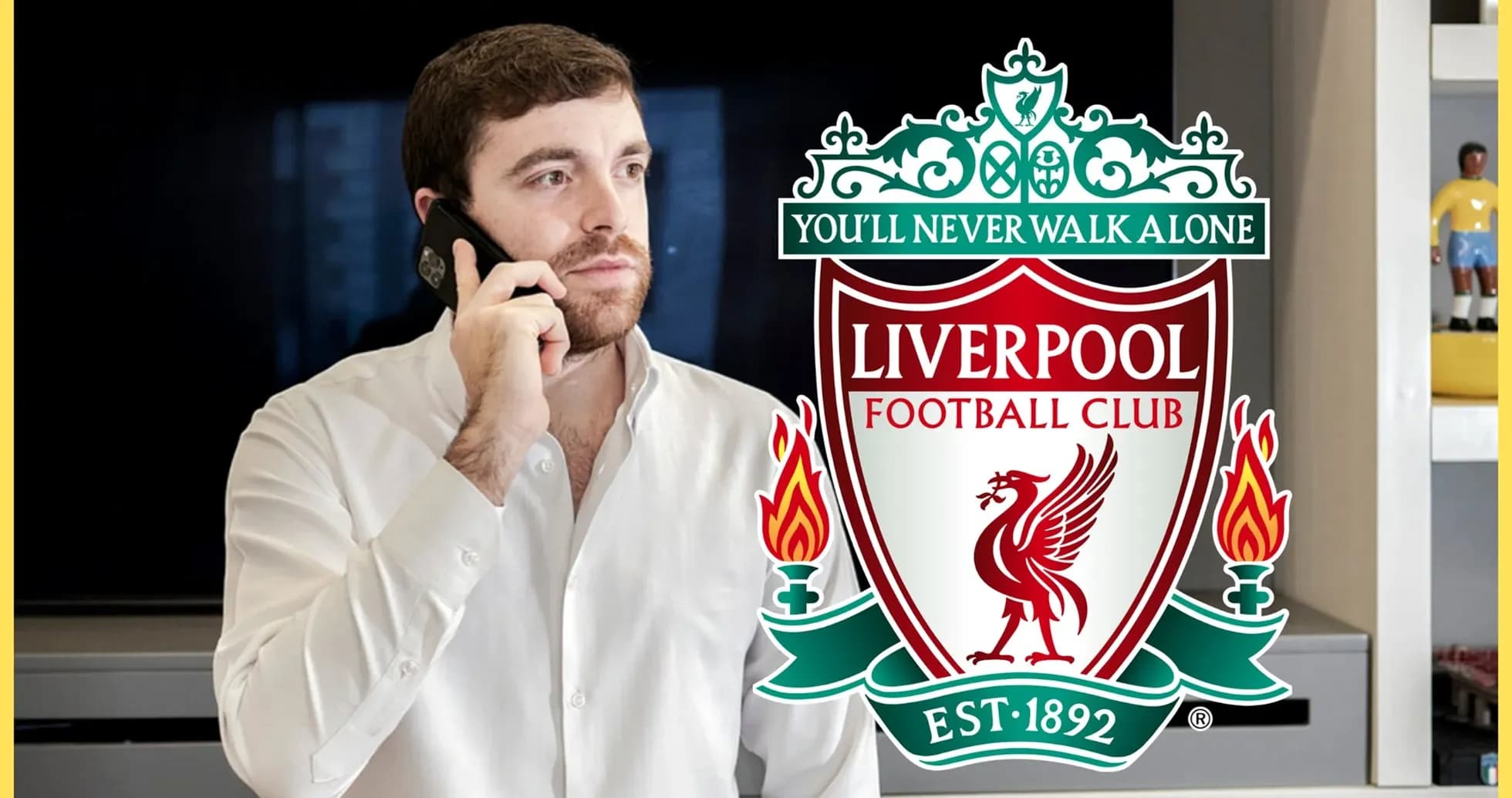 Man talking on phone near Liverpool FC logo
