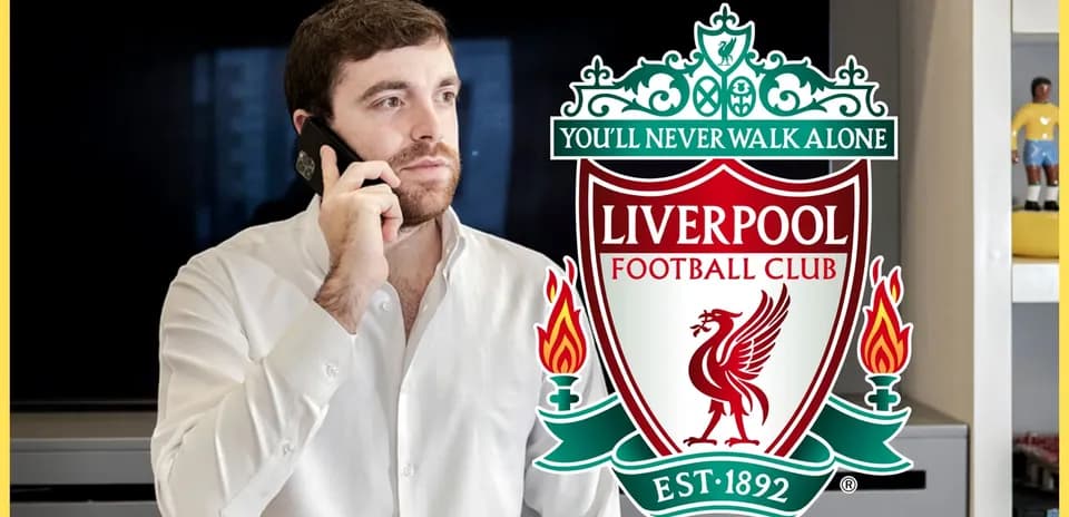 Man talking on phone near Liverpool FC logo