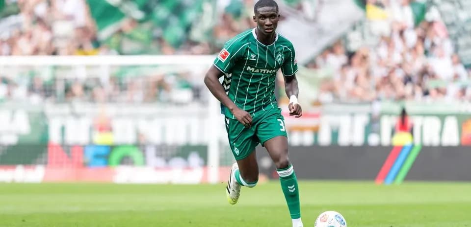 Futbolchi maydonda to'p bilan harakat qilmoqda
