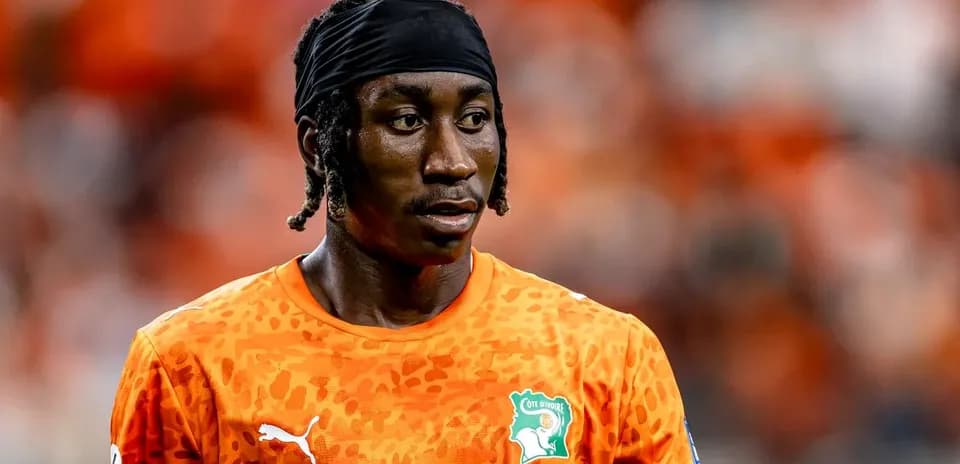Futbolchi oranj rangli forma kiyib turibdi