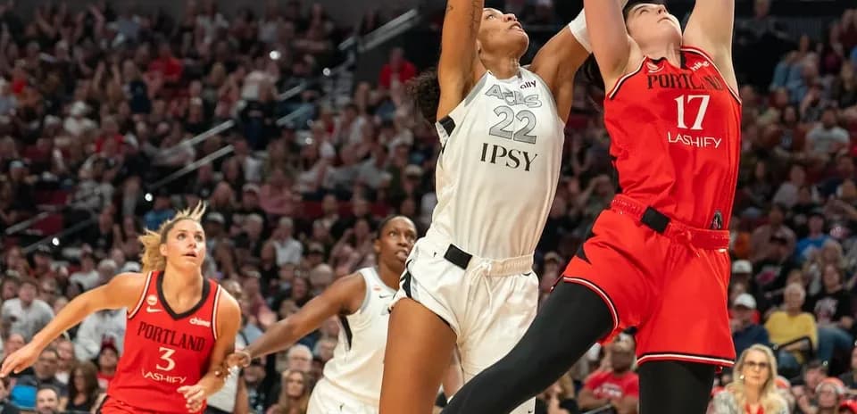 Two players jumping for the basketball during game