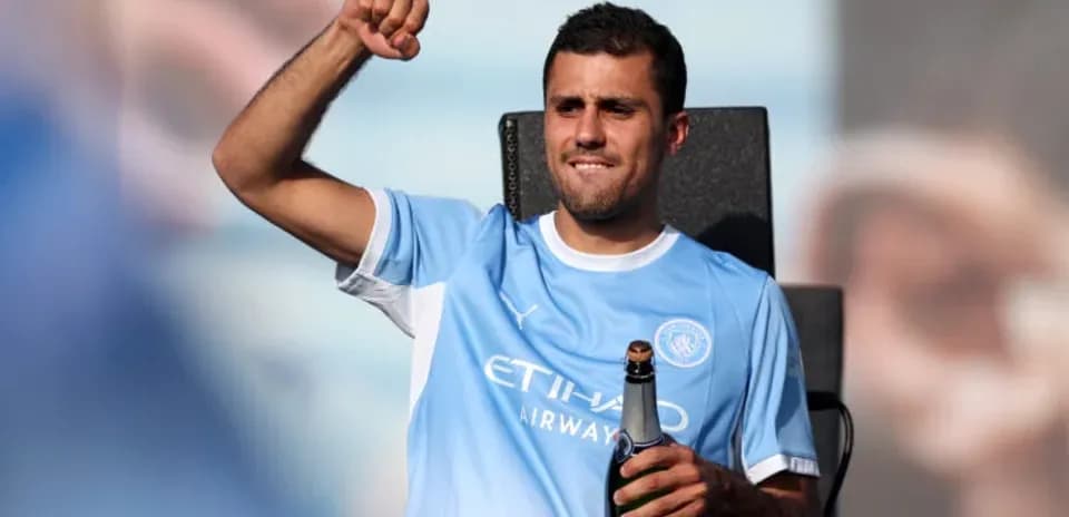 Futbolchi shampan bilan sahnada qo'l ko'taradi