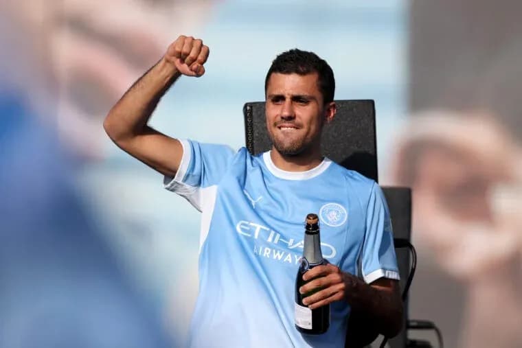 Futbolchi shampan bilan sahnada qo'l ko'taradi
