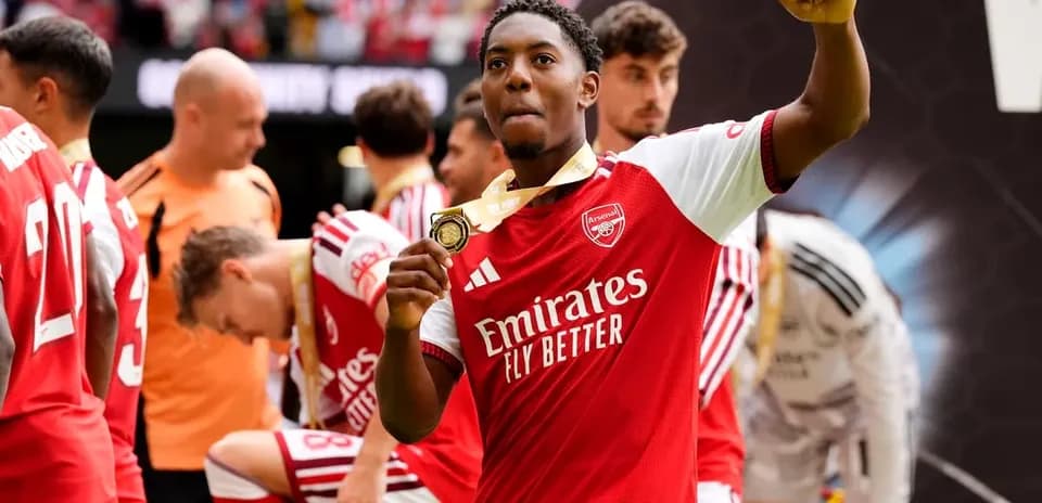 Arsenal player celebrating with a medal