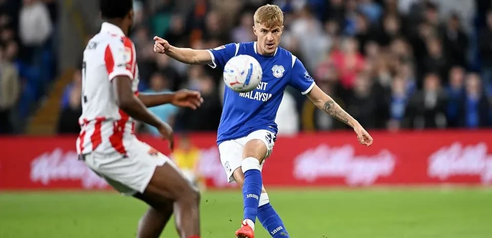 O'yinchi to'pni zarba berayotgan futbol maydonida