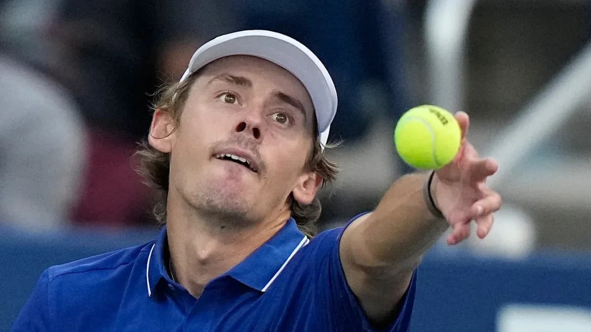 Tennis player serving ball during match