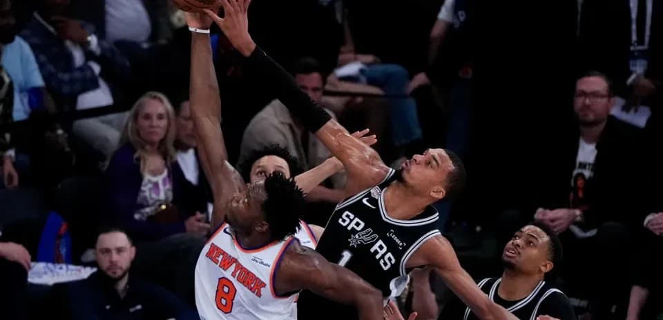 New York player attempts dunk against San Antonio defenders