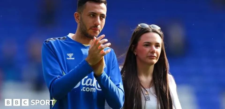 Football player and companion walking on the pitch
