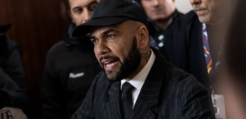 Dani Alves speaking surrounded by reporters and supporters