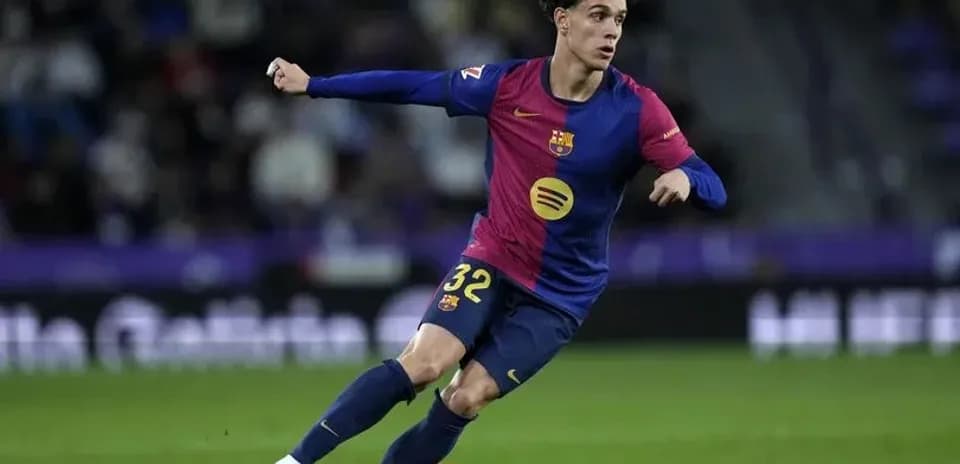Futbolchi Barcelona formasida to'pni quchoqda ushlamoqda