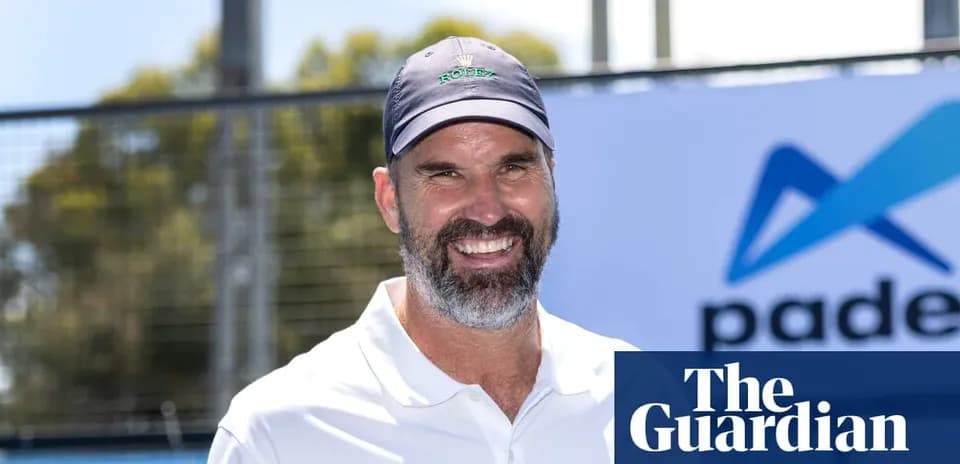 Man smiling at padel event with branding in background