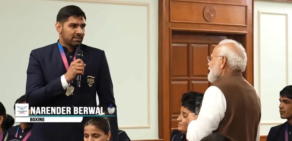 Narender Berwal speaking at an event with audience