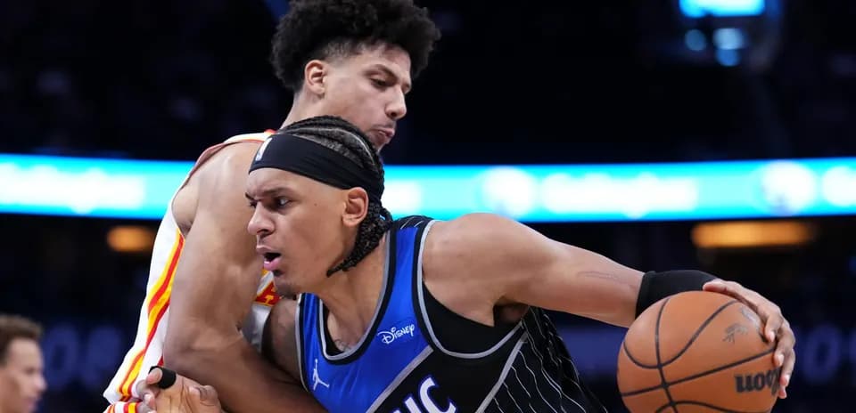 Two basketball players battling for possession of the ball