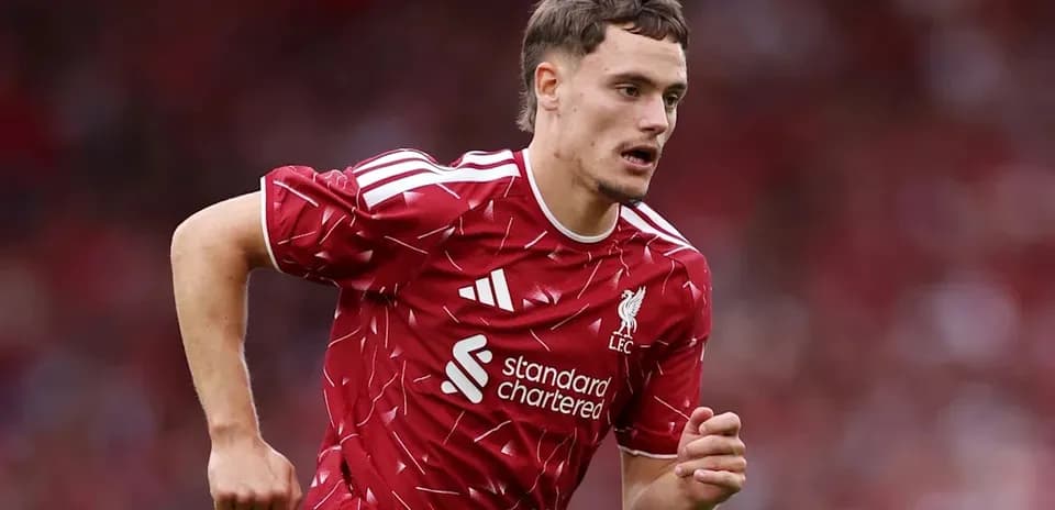 Futbolchi maydonda yugurayotgan Liverpool formasida