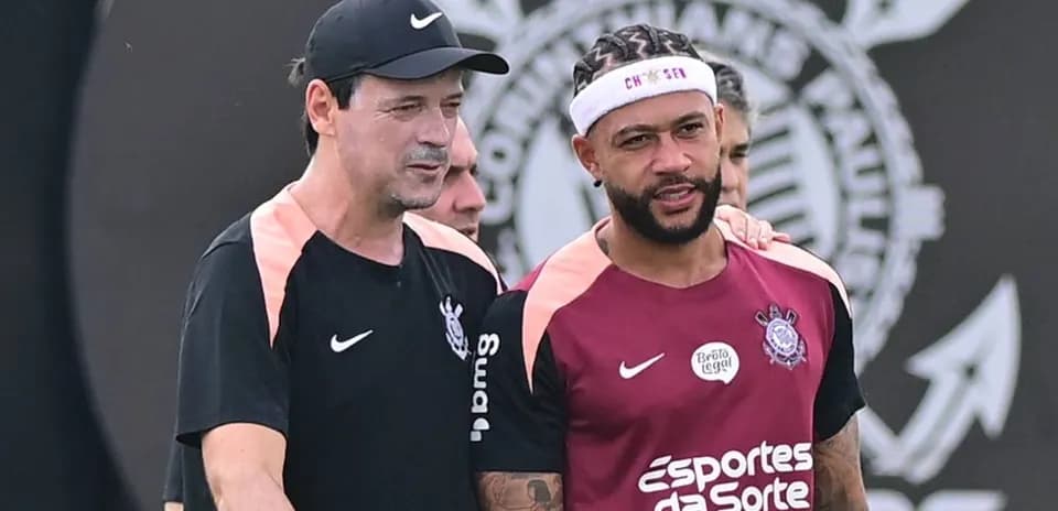 Trener va futbolchi trening paytida suhbatlashmoqda