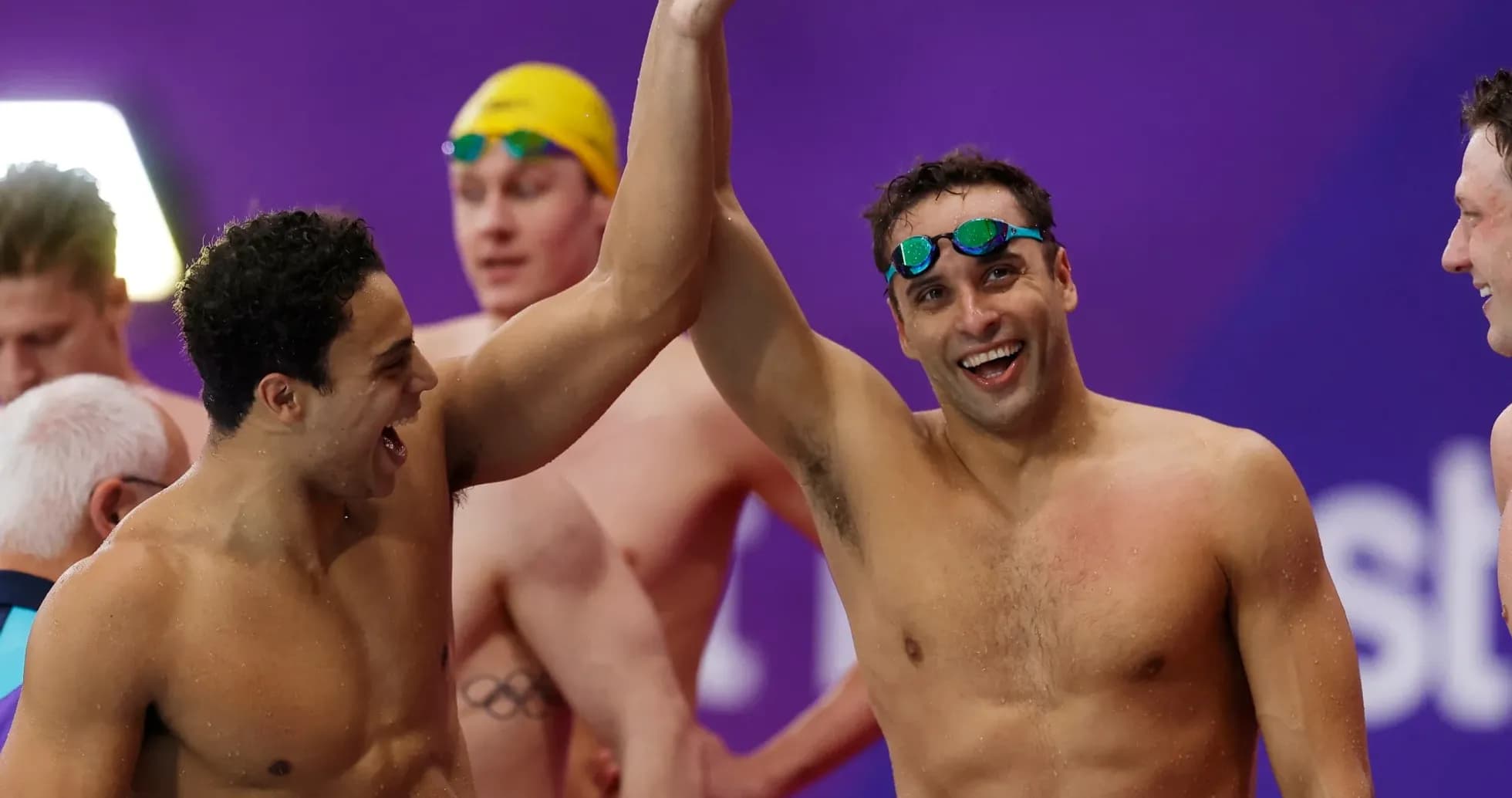 Swimmers celebrating with raised arms after competition Swimmers celebrating with raised arms after competition