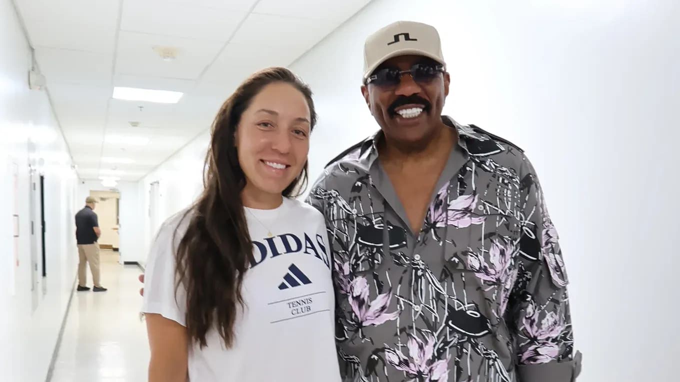 Tennis player posing with a man in hallway Tennis player posing with a man in hallway