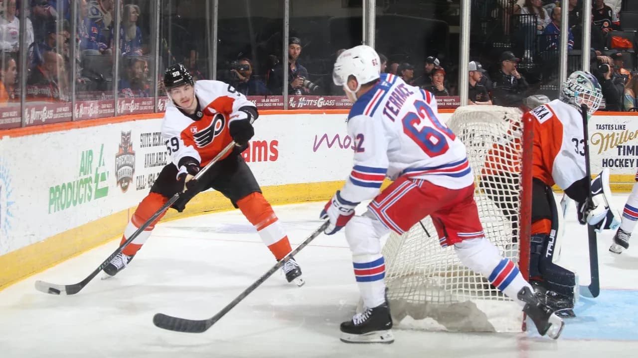 Flyers player skates with puck near Rangers goal Flyers player skates with puck near Rangers goal