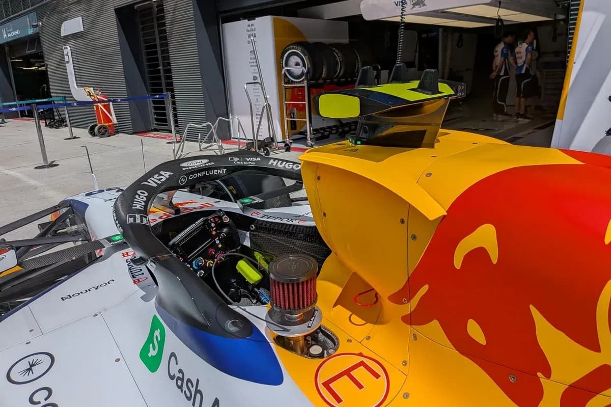 F1 car in the pit lane with team members F1 car in the pit lane with team members