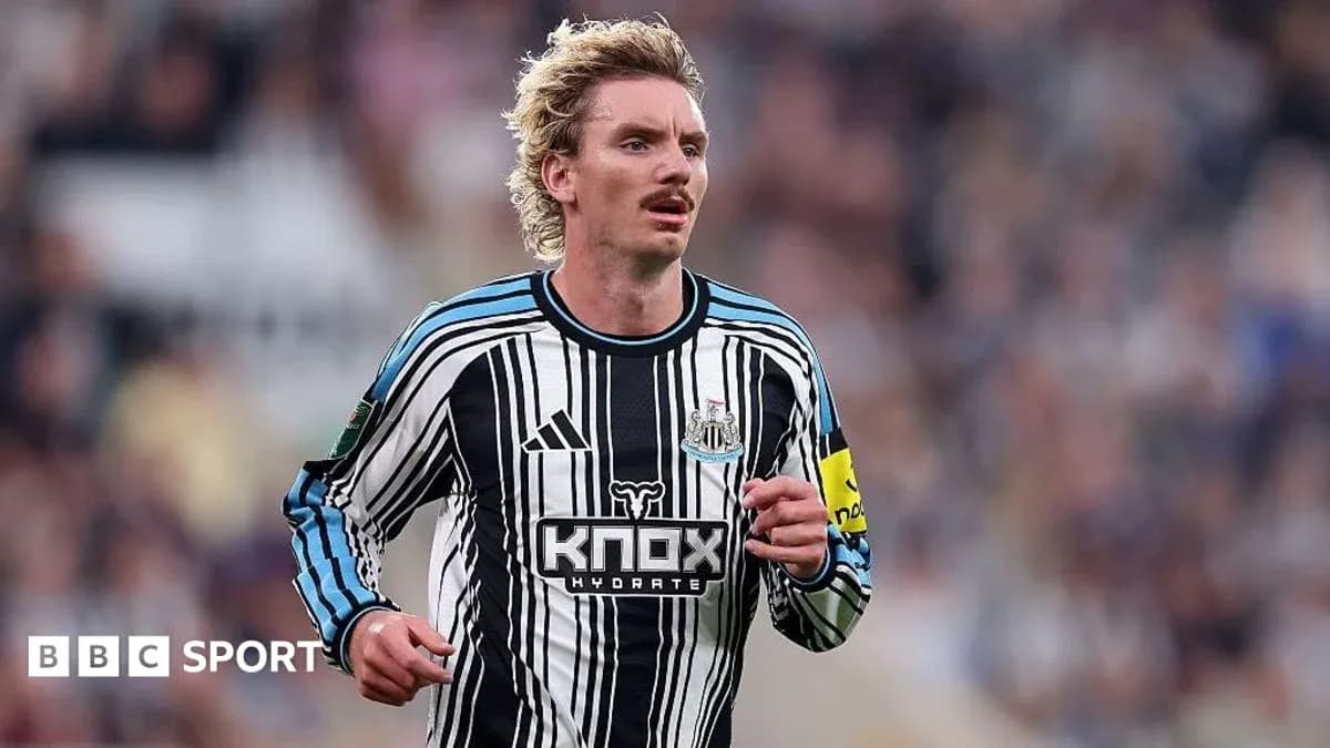 Futbolchi Newcastle formasida maydon bo'ylab yugurmoqda Futbolchi Newcastle formasida maydon bo'ylab yugurmoqda