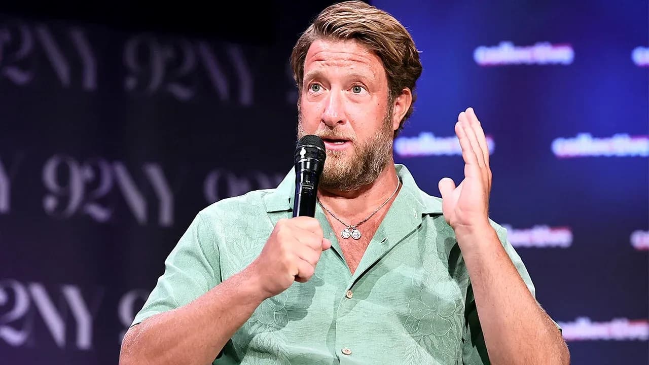 Speaker gesturing while holding a microphone on stage Speaker gesturing while holding a microphone on stage