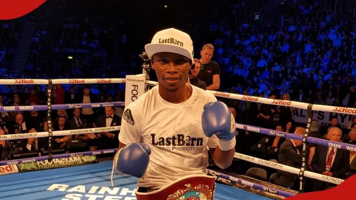 Boxer posing with championship belt in ring Boxer posing with championship belt in ring