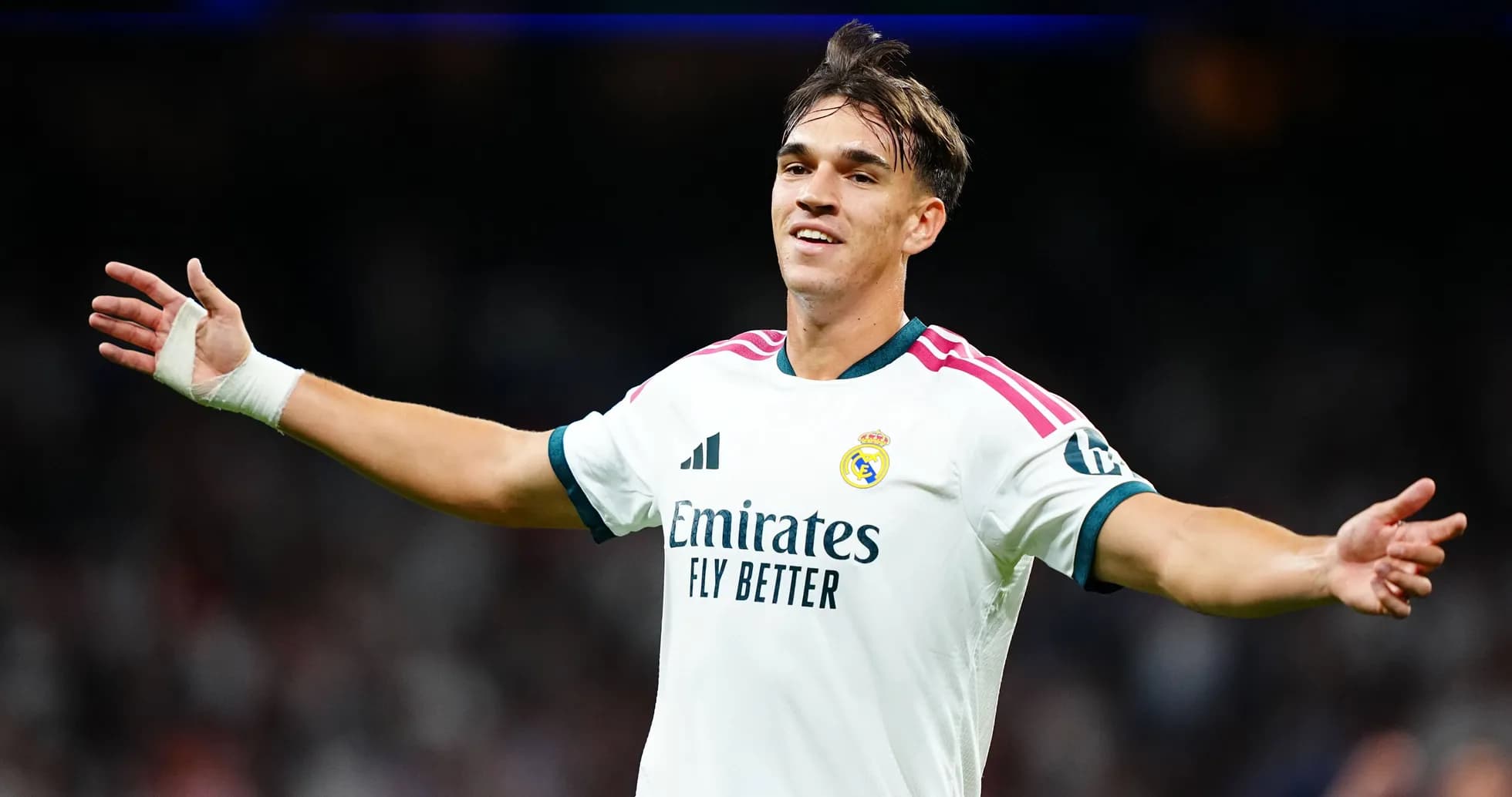 Futbolchi Real Madrid formasida maydonni ko'rsatmoqda Futbolchi Real Madrid formasida maydonni ko'rsatmoqda