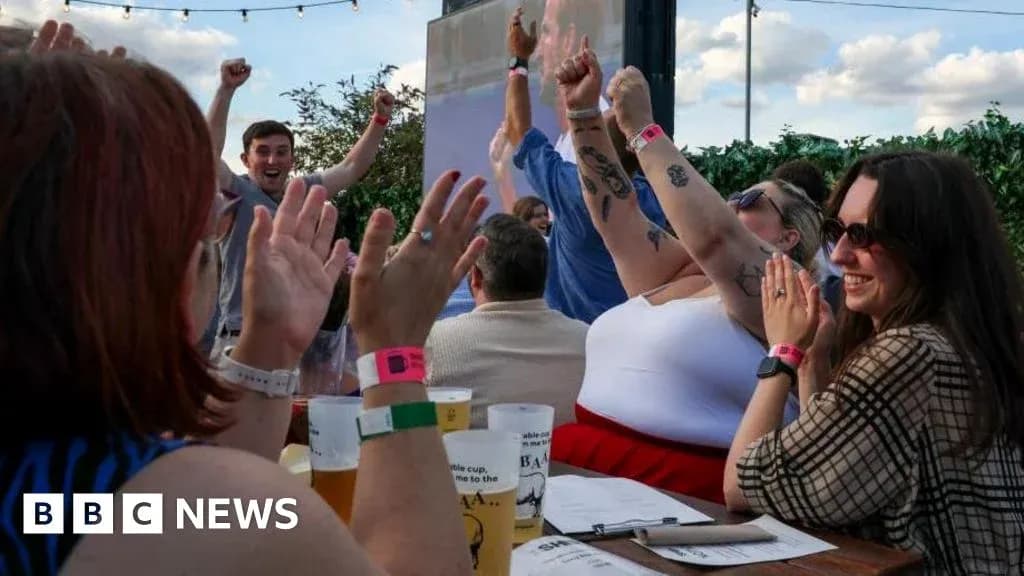 People celebrating at outdoor venue with raised hands People celebrating at outdoor venue with raised hands
