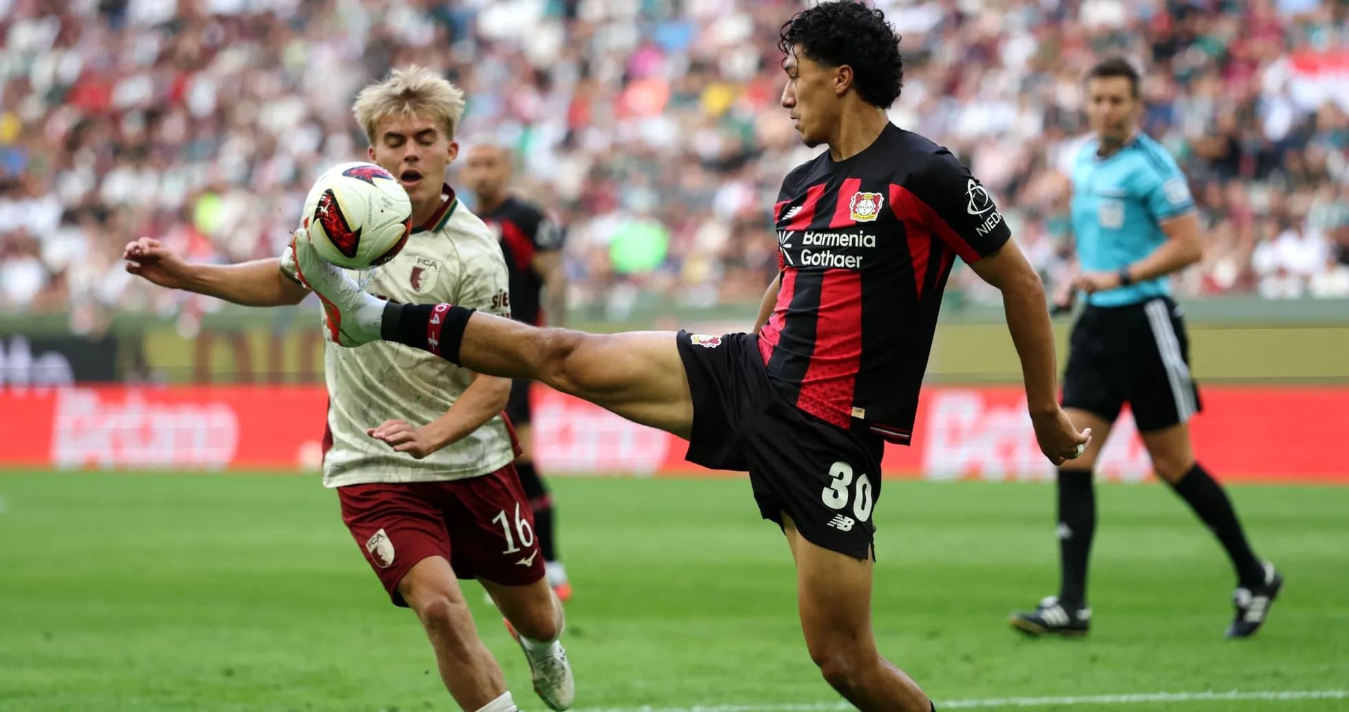 Bayer Leverkusen player kicking ball against opponent Bayer Leverkusen player kicking ball against opponent