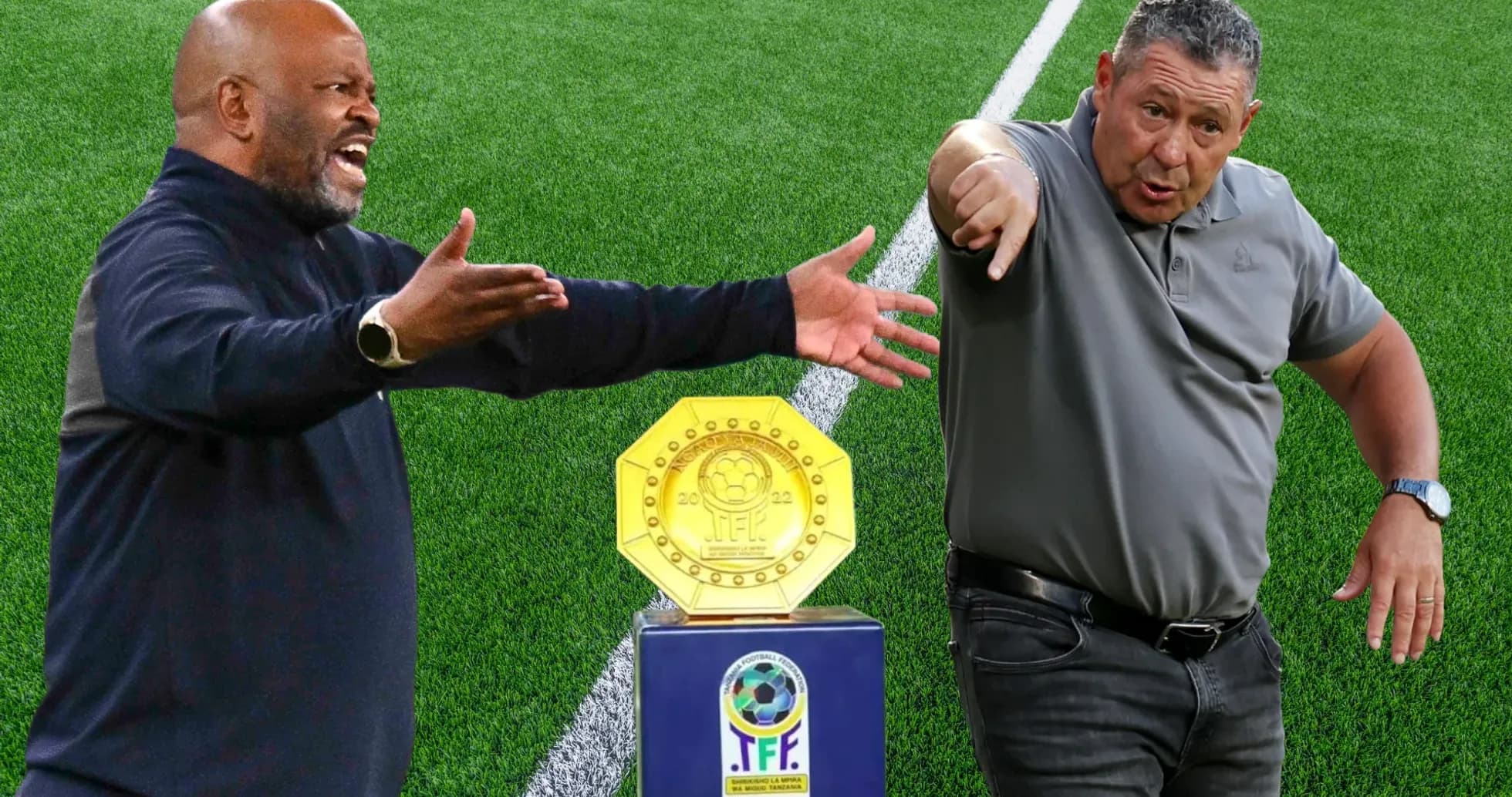 Two football coaches gesturing beside trophy on pitch Two football coaches gesturing beside trophy on pitch
