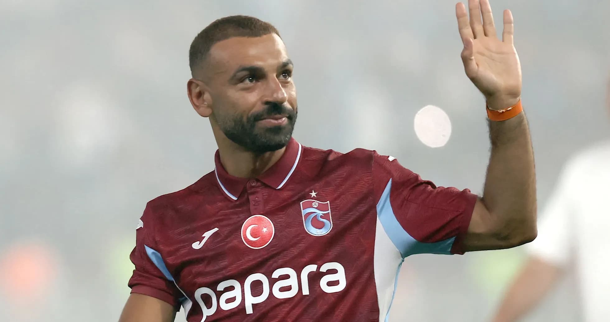 Futbolchi tribuna tomon qo'lini ko'tarib salom beradi Futbolchi tribuna tomon qo'lini ko'tarib salom beradi