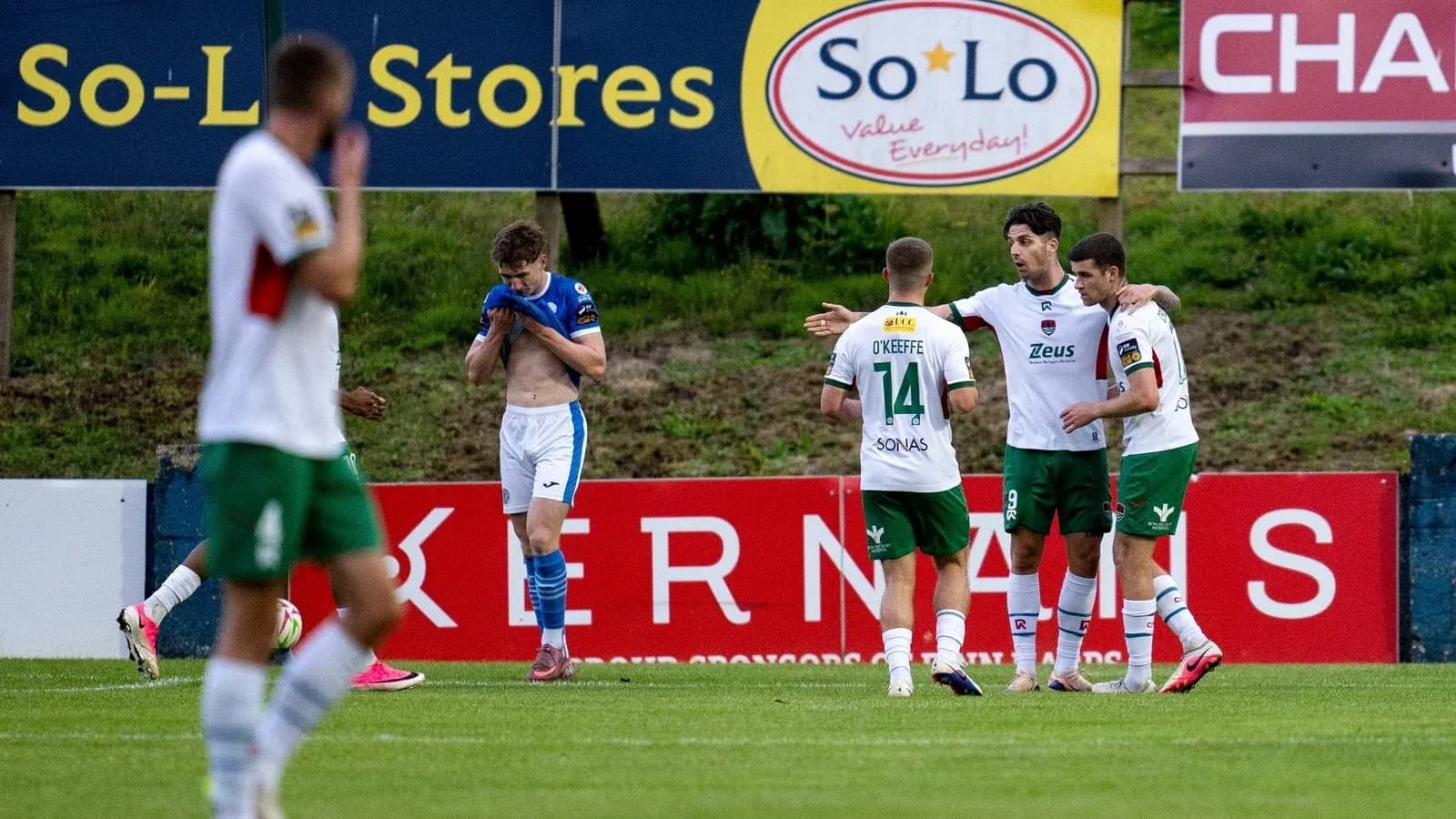 Players celebrating a goal on the pitch Players celebrating a goal on the pitch