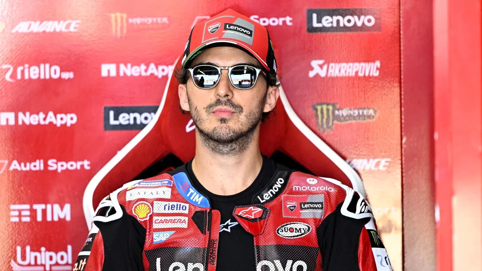 Rider wearing sunglasses in pit area Rider wearing sunglasses in pit area