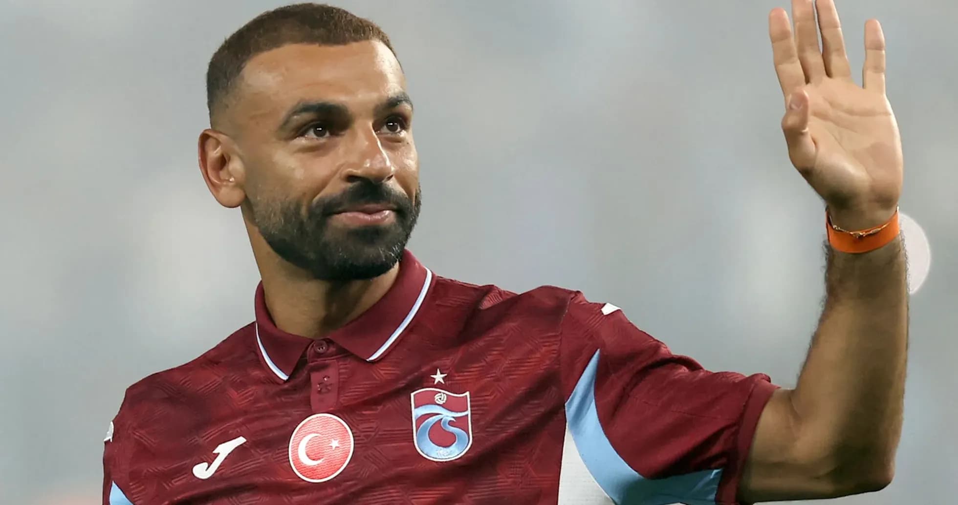 Futbolchi qo'l silkitib tomoshabinlarga salom bermoqda Futbolchi qo'l silkitib tomoshabinlarga salom bermoqda