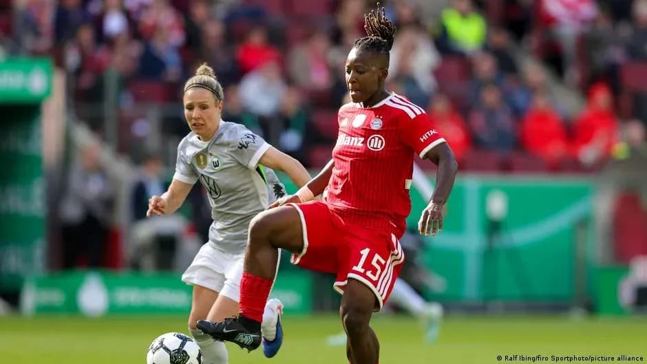 Bayern player controlling ball against Wolfsburg opponent Bayern player controlling ball against Wolfsburg opponent