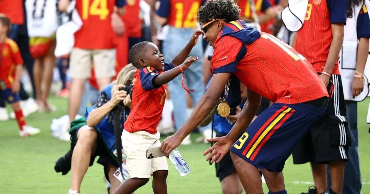 Bola o'yinida g'olib bo'lgan futbolchi va bola Bola o'yinida g'olib bo'lgan futbolchi va bola