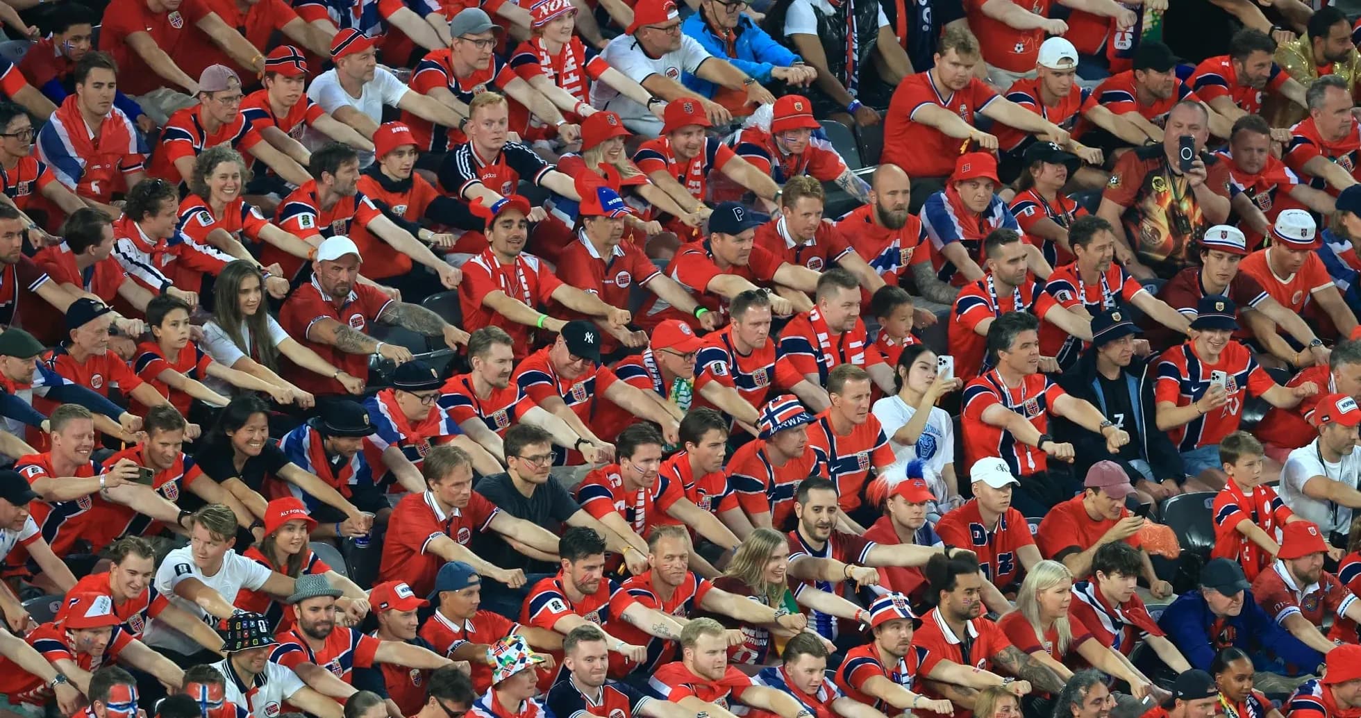 Futbol stadionida qizil formadagi muxlislar yig'ilishi Futbol stadionida qizil formadagi muxlislar yig'ilishi